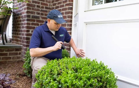 technician inspecting a home for pest problems