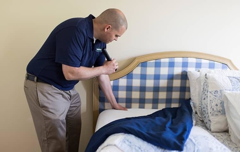 man inspecting the bed sheet