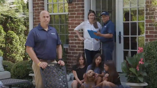 A technician with a family outside their home.