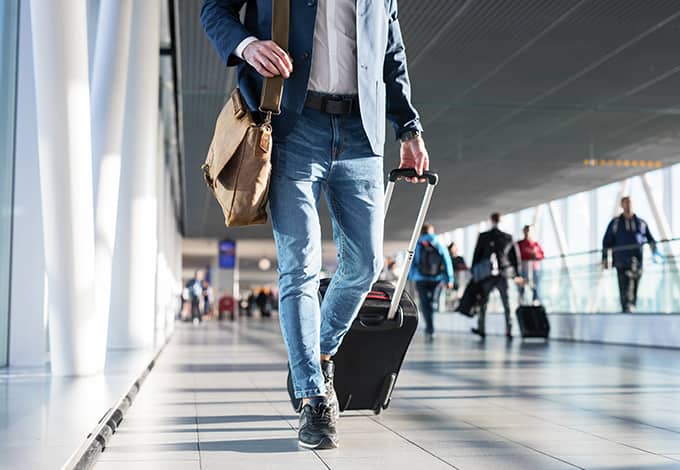 A man travelling while pulling his suitcase