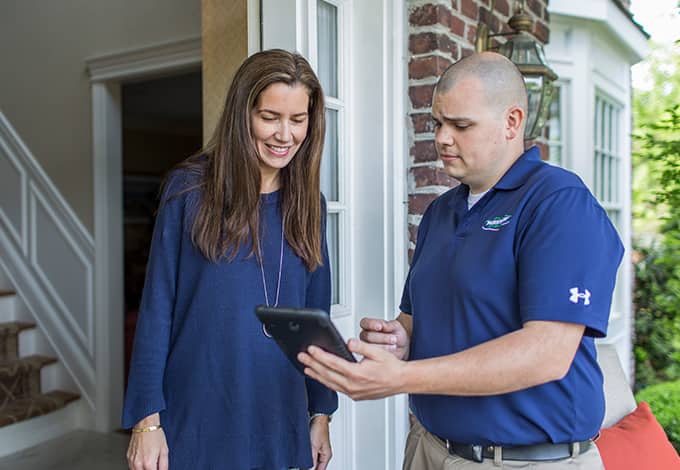 Pest control staff showing information to a homeowner