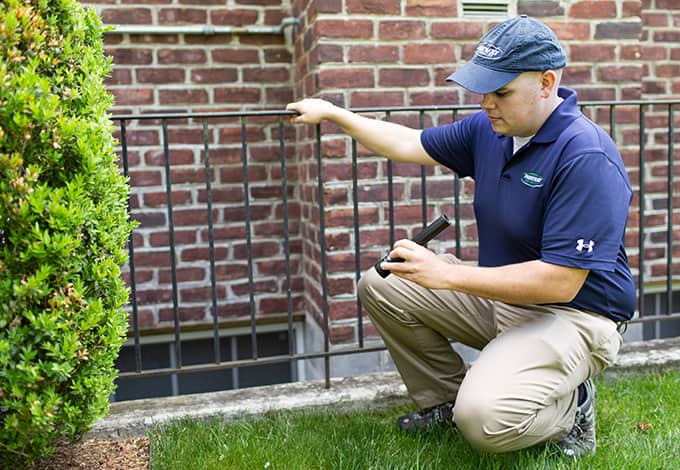 Technician inspecting a residential property exterior 