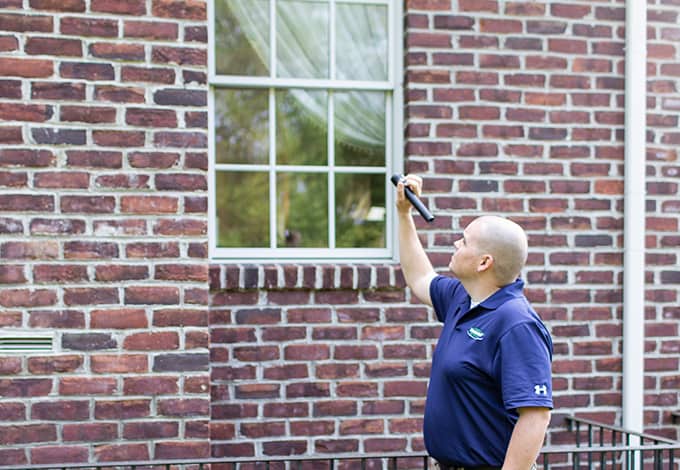 A professional inspecting a brick house