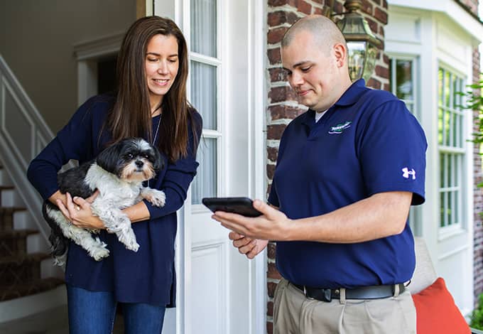 Pest control technician showing information to a homeowner