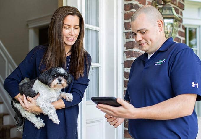Pest control technician showing information to a homeowner